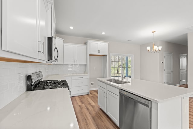 112 Lakota Loop, Longs, SC 29568 - kitchen with stainless steel appliances, a sink, light wood-style flooring, light countertops, and tasteful backsplash