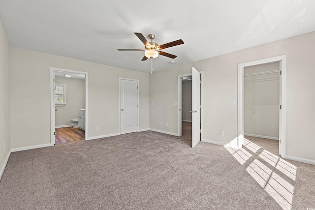 112 Lakota Loop, Longs, SC 29568 - unfurnished bedroom with carpet, a walk in closet, baseboards, ensuite bathroom, and ceiling fan
