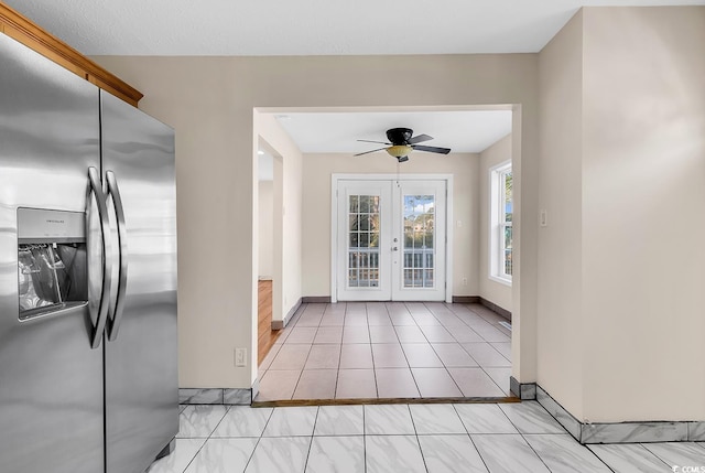 tiled foyer entrance featuring ceiling fan and french doors