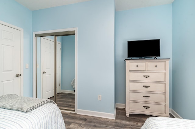 bedroom with dark hardwood / wood-style floors and a closet