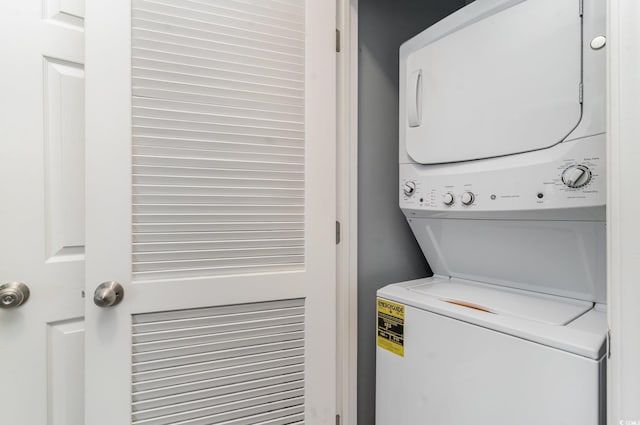 clothes washing area featuring stacked washer and dryer