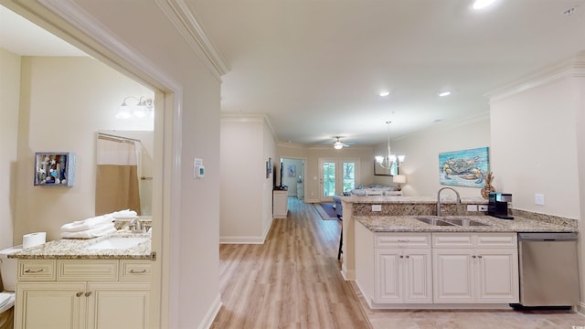 kitchen featuring dishwasher, light stone countertops, and sink