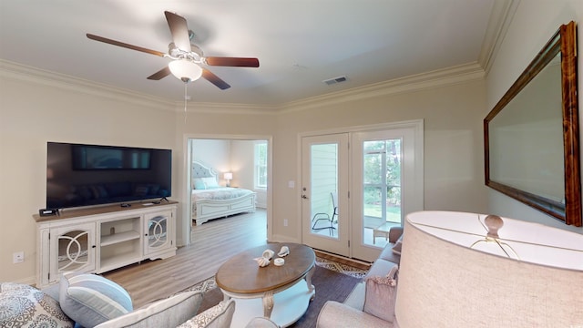 living room featuring crown molding, ceiling fan, and light wood-type flooring