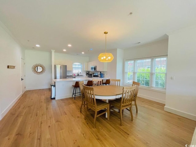 dining area featuring light wood-type flooring and sink