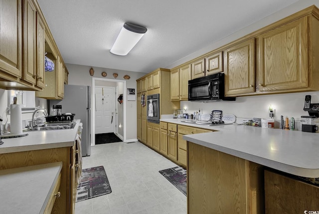 kitchen with black appliances, kitchen peninsula, sink, and a textured ceiling