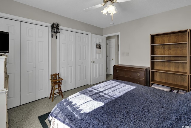 bedroom with ceiling fan, carpet, and multiple closets