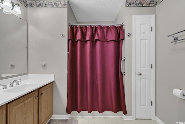 bathroom with a textured ceiling, walk in shower, and vanity