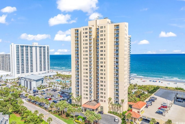 view of building exterior featuring a beach view and a water view