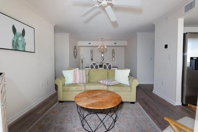 living room featuring crown molding, ceiling fan with notable chandelier, a textured ceiling, and dark wood-type flooring