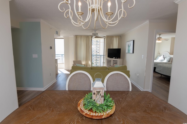 dining space featuring ceiling fan with notable chandelier, wood-type flooring, and ornamental molding