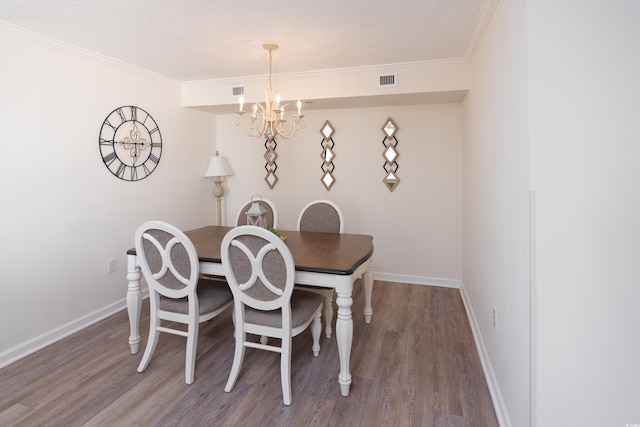 dining area with an inviting chandelier, hardwood / wood-style flooring, and ornamental molding