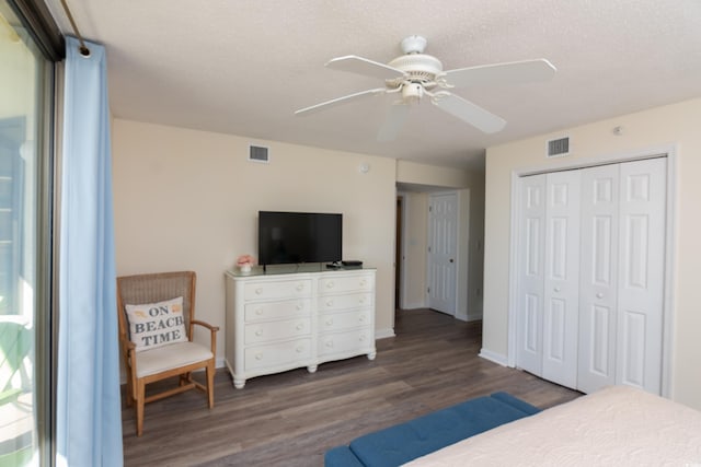 bedroom featuring ceiling fan, dark hardwood / wood-style flooring, a closet, and a textured ceiling