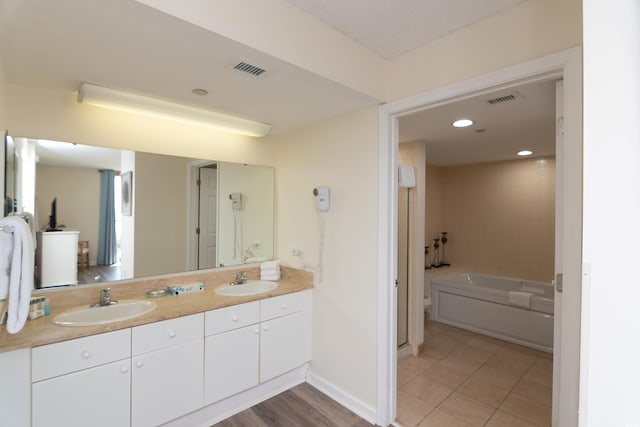 bathroom with tiled shower / bath, vanity, and tile patterned flooring