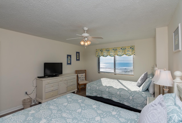 bedroom with ceiling fan, wood-type flooring, and a textured ceiling