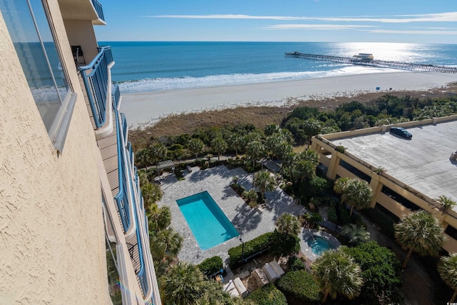 birds eye view of property featuring a water view and a beach view