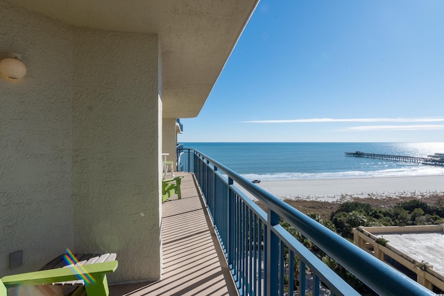 balcony with a water view and a beach view