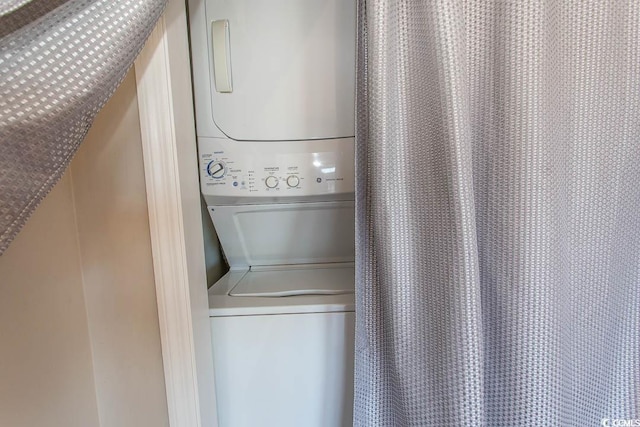 clothes washing area with stacked washer / dryer