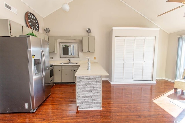 kitchen featuring appliances with stainless steel finishes, high vaulted ceiling, sink, ceiling fan, and dark wood-type flooring