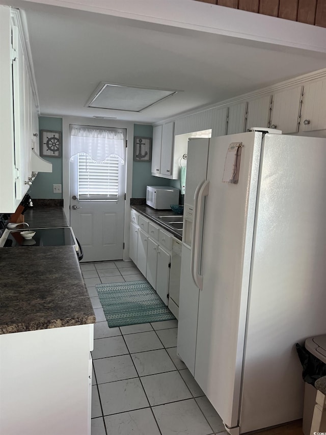 kitchen with white cabinetry, light tile patterned floors, and white appliances