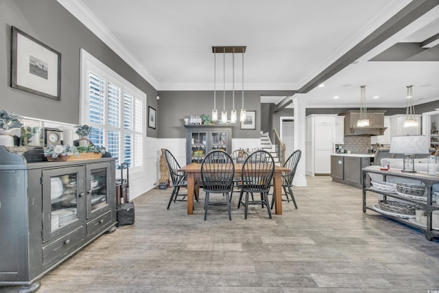 dining space with crown molding and light hardwood / wood-style floors