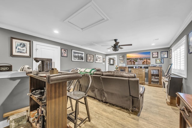 living room with ornamental molding, light hardwood / wood-style floors, and ceiling fan