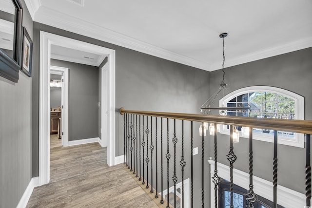 hall featuring ornamental molding, a chandelier, and light hardwood / wood-style flooring