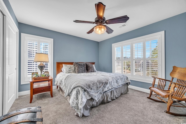 bedroom featuring a closet, ceiling fan, carpet floors, and multiple windows