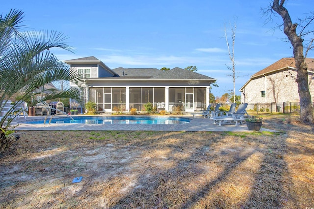 rear view of house with a fenced in pool, a patio area, and a sunroom