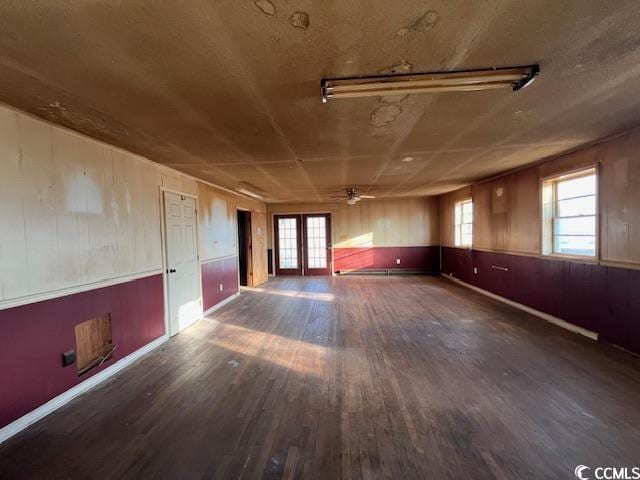 empty room featuring french doors, ceiling fan, and dark hardwood / wood-style floors