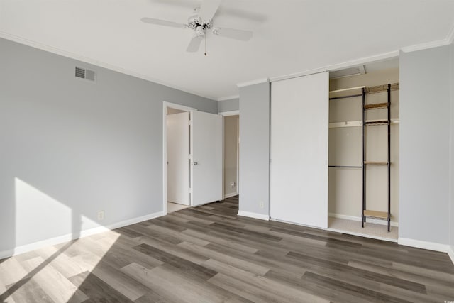 unfurnished bedroom with ceiling fan, hardwood / wood-style floors, a closet, and crown molding