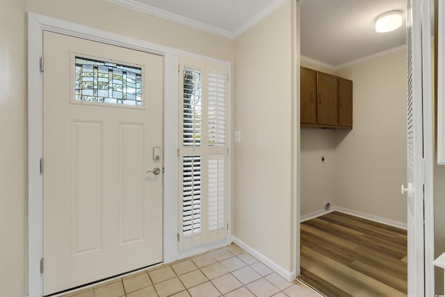 tiled foyer with a textured ceiling and crown molding