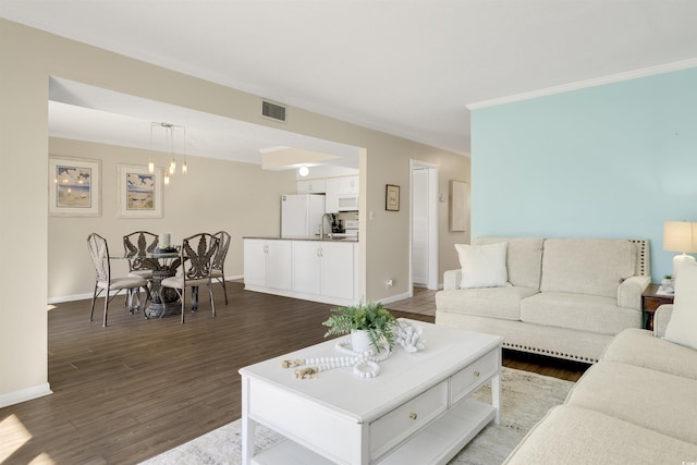 living room featuring crown molding, dark hardwood / wood-style floors, and sink