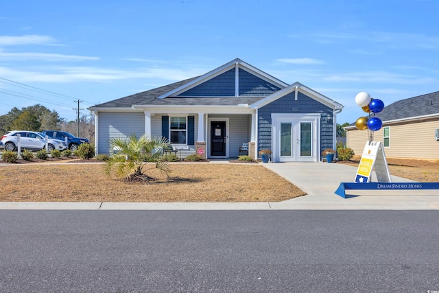 view of front of home featuring covered porch and french doors