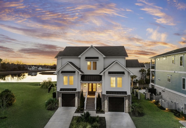 view of front of property with a garage, a yard, and a water view