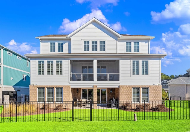 view of front of home with a front yard, a sunroom, and a patio