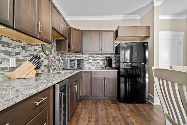 kitchen featuring dark hardwood / wood-style floors, backsplash, black fridge, beverage cooler, and light stone counters