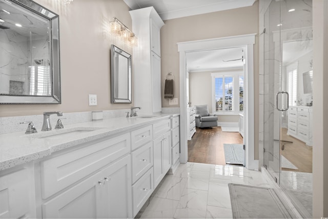 bathroom with an enclosed shower, vanity, and ornamental molding