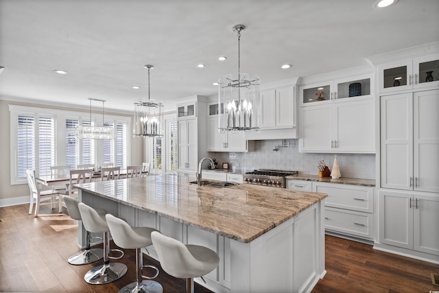 kitchen with pendant lighting, sink, dark wood-type flooring, a large island, and white cabinets