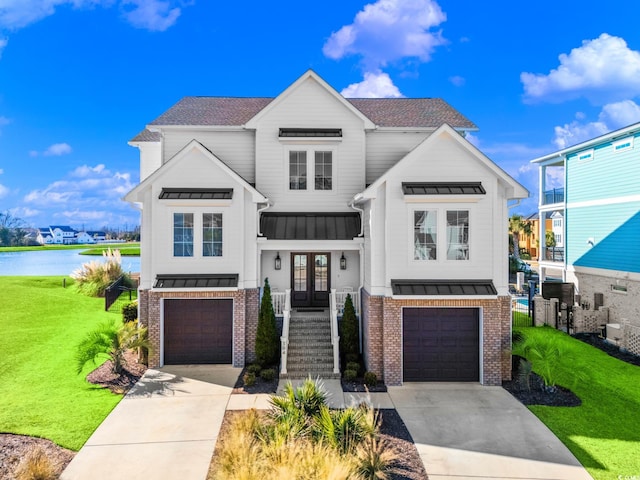 modern inspired farmhouse featuring a water view, french doors, a front yard, and a garage