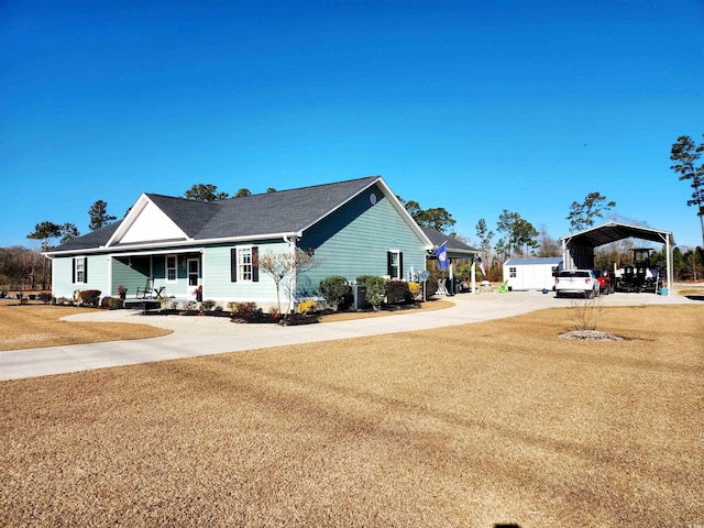 view of side of home featuring a yard, concrete driveway, and a detached carport