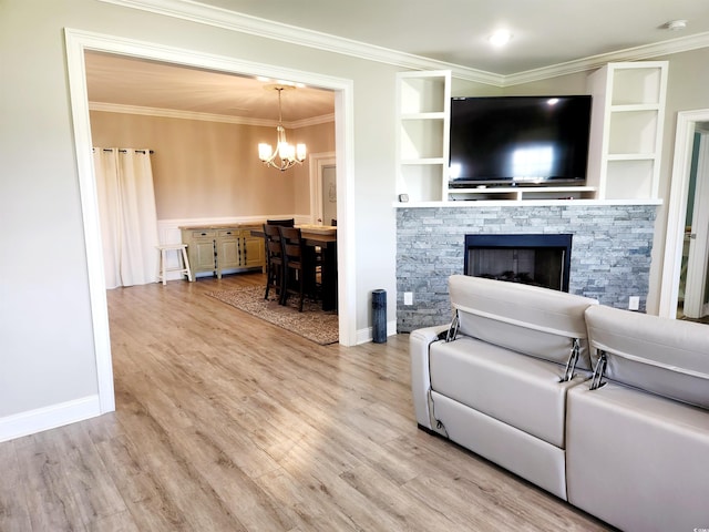 living room with an inviting chandelier, ornamental molding, and light wood-style floors
