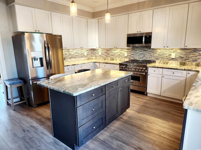 kitchen featuring stainless steel appliances, white cabinets, backsplash, and wood finished floors