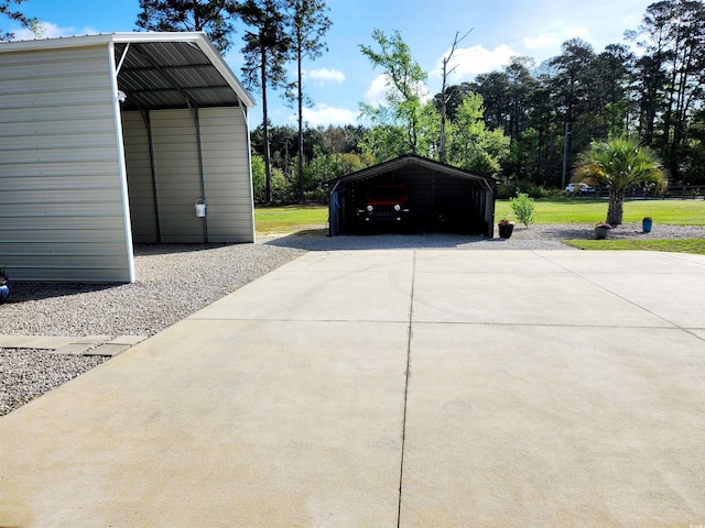 garage with driveway and a detached carport