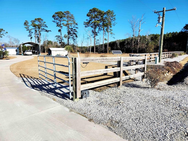 exterior space with a gate, fence, and a detached carport