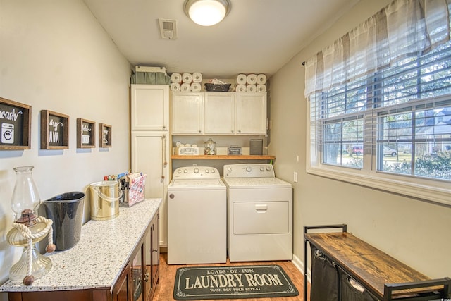 washroom with independent washer and dryer and cabinets