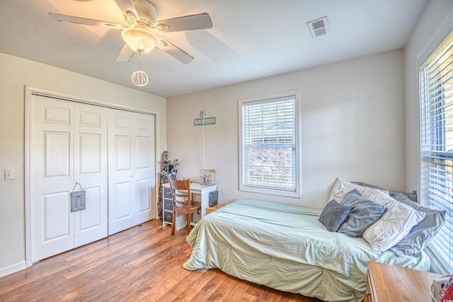 bedroom with ceiling fan, a closet, and dark hardwood / wood-style floors