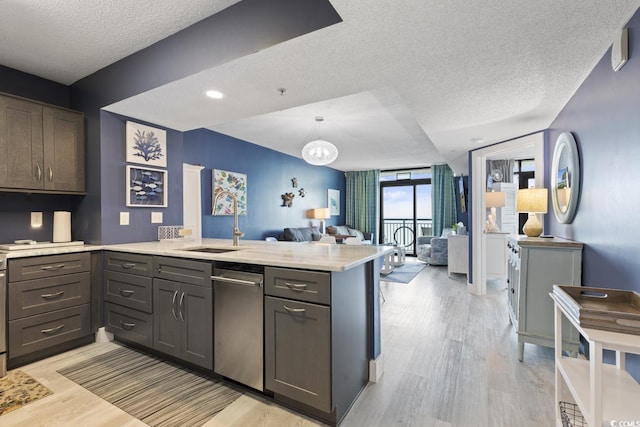 kitchen featuring decorative light fixtures, kitchen peninsula, light wood-type flooring, and floor to ceiling windows