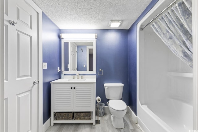 full bathroom featuring toilet, vanity, hardwood / wood-style flooring, a textured ceiling, and shower / bath combo with shower curtain