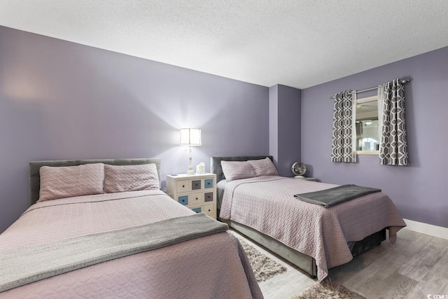 bedroom featuring a textured ceiling and hardwood / wood-style flooring