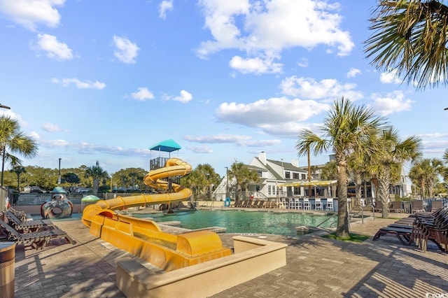 view of pool with a water slide and a patio